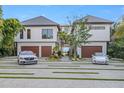 Contemporary home featuring a stylish driveway, manicured lawn, and a two-car garage at 5861 Gulf Of Mexico Dr, Longboat Key, FL 34228