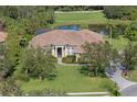 Aerial view of a home featuring a barrel tile roof, well-maintained lawn, and circular driveway at 10209 Discovery Ter, Bradenton, FL 34212