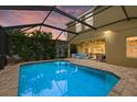 Relaxing pool with screened enclosure, featuring an outdoor seating area, and tropical landscaping at 12224 Longview Lake Cir, Bradenton, FL 34211