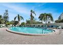 Bright community pool surrounded by palm trees and lounge chairs, perfect for relaxation on a sunny day at 3660 Ironwood Cir # 101M, Bradenton, FL 34209