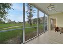 Bright sunroom showcasing panoramic views of the lush green golf course and serene landscaping at 3660 Ironwood Cir # 101M, Bradenton, FL 34209
