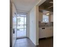 Inviting condo entryway featuring tiled floors, leading to a bright living space and partial kitchen view at 4452 Garnet Dr # 205, New Port Richey, FL 34652