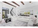 Spacious living room with a large sectional sofa, open floor plan, and staircase leading to the upper level at 5910 Gulf Of Mexico Dr, Longboat Key, FL 34228