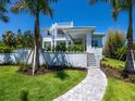 Modern two-story home with a spiral staircase and lush landscaping at 5910 Gulf Of Mexico Dr, Longboat Key, FL 34228