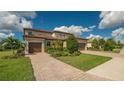 Two-story house with tile roof, two-car garage, and lush landscaping at 6771 Wild Lake Ter, Bradenton, FL 34212