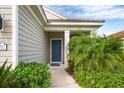 Front door entrance with a blue door and lush landscaping at 12741 Coastal Breeze Way, Bradenton, FL 34211