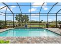 Gorgeous in-ground pool featuring a screen enclosure and waterfall feature at 17802 Eastbrook Ter, Lakewood Ranch, FL 34202