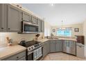Gray cabinets, stainless steel appliances, and an island with seating at 3226 44Th E Dr, Bradenton, FL 34203