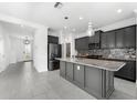 Modern kitchen with granite island, gray cabinets, and tile floors at 4704 Foxtail Dr, Parrish, FL 34219