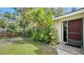 Front exterior of home with mature landscaping and a red front door at 766 N Jefferson Ave # 766, Sarasota, FL 34237