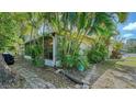 Back exterior showing a screened porch and lush tropical landscaping at 766 N Jefferson Ave # 766, Sarasota, FL 34237