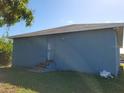 Rear view of a blue house with a back door and yard at 1308 72Nd E St, Palmetto, FL 34221