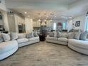 Open-concept living room with wood flooring and seamless flow into the kitchen at 15618 Castle Park Ter, Lakewood Ranch, FL 34202