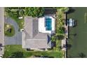 Aerial view showcasing home with pool, boat dock, lush green lawn, and driveway at 1649 Stanford Ln, Sarasota, FL 34231