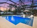 Enclosed pool and spa area with lounge chairs at sunset at 1827 Morris St, Sarasota, FL 34239
