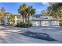 Front view of a light green two-story building with a metal roof and attached garages at 294 Hidden Bay Dr # 203, Osprey, FL 34229