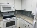 White cabinets and granite countertops in this well-lit kitchen at 3751 S School Ave # 29, Sarasota, FL 34239