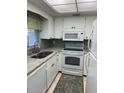 Bright kitchen features granite countertops and white appliances at 3751 S School Ave # 29, Sarasota, FL 34239