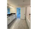 Bathroom featuring double vanity, tub, and light gray tile floors at 5605 Gaffney Avenue, North Port, FL 34291