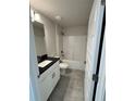 Bathroom featuring a vanity with a dark countertop, tub, and light gray tile floors at 5605 Gaffney Avenue, North Port, FL 34291