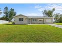Front view of the house with a large green lawn at 6352 Coniston Ter, North Port, FL 34287