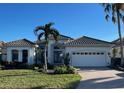 One-story home with tile roof, white exterior, and palm trees at 7060 Whitemarsh Cir, Lakewood Ranch, FL 34202