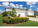 White two-story house with three-car garage, landscaping, and a paved driveway at 14538 Barefoot Ln, Parrish, FL 34219