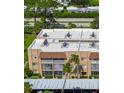A view of the exterior elevation of the condo building with parking and trees at 1540 Glen Oaks E Dr # B336, Sarasota, FL 34232