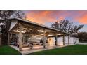 Covered boat storage area with lighting, next to a white detached garage and lush landscaping at 1640 Center Rd, Terra Ceia, FL 34250