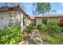 Front exterior of charming villa with walkway and landscaping at 4573 Pine Green Trl # 1, Sarasota, FL 34241