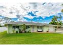 Ranch-style home with a green exterior and nicely landscaped yard at 4817 Sarasota Ave, Sarasota, FL 34234