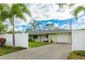 Light green house with a white fence and palm trees at 4817 Sarasota Ave, Sarasota, FL 34234