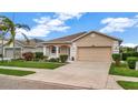 Tan one-story house with two-car garage and landscaped yard at 8019 Haven Harbour Way, Bradenton, FL 34212