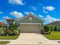 Single-story home with light teal exterior, beige garage door, and landscaped front yard at 12715 Coastal Breeze Way, Bradenton, FL 34211