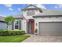 Two-story house with gray siding, coral door, and paver driveway at 16742 Savory Mist Cir, Bradenton, FL 34211