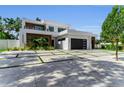 A beautifully landscaped modern home featuring a sleek design, elegant driveway, and ample parking at 2038 Datura St, Sarasota, FL 34239