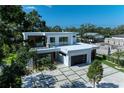Aerial view of a modern, two-story home with flat roof, lush greenery, and a unique driveway at 2038 Datura St, Sarasota, FL 34239