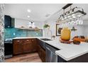 Modern kitchen highlighting a large island, stainless steel sink, and distinctive blue tile backsplash at 3700 S Osprey Ave # 214, Sarasota, FL 34239