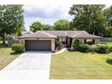 One-story home with a brown garage door and well-maintained lawn at 7126 Sonata Dr, Port Richey, FL 34668