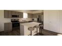 Modern kitchen with gray cabinets, island, and stainless steel appliances at 13020 Cedar Elm Lane, Parrish, FL 34219