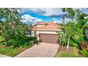 Single-story home with brown garage door and brick driveway at 335 River Enclave Ct, Bradenton, FL 34212