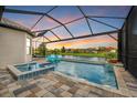 Inviting pool and spa with a covered patio and lake view at 4612 Stickley Ct, Palmetto, FL 34221