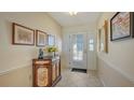 Bright entryway with tiled floor, decorative cabinet, and stained-glass door at 5692 Country Lakes Dr, Sarasota, FL 34243