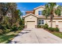 Tan three-story townhome with two-car garage at 8256 Enclave Way # 101, Sarasota, FL 34243