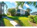 Exterior shot of condominium with lush landscaping and a well-maintained lawn at 8706 54Th W Ave # 18, Bradenton, FL 34210