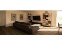 Modern living room with dark sofa, shelving unit and large TV at 13028 Cedar Elm Lane, Parrish, FL 34219