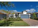 One-story home with gray garage door and landscaping at 13250 Esposito St, Venice, FL 34293