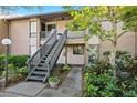 Condo entrance with stairs and tropical landscaping at 1717 Pelican Cove Rd # 334, Sarasota, FL 34231