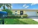 Front view of a yellow house with a white garage door and landscaping at 3712 Hampshire Ln # 5623, Sarasota, FL 34232