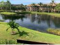 Scenic pond view featuring a fountain, lush landscaping, and beautiful building architecture at 5644 Ashton Lake Dr # 5644, Sarasota, FL 34231